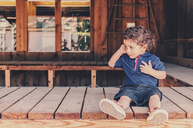 migraines in children, child sitting down touching head