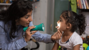 Dr-Rukshin Masters examining child patient